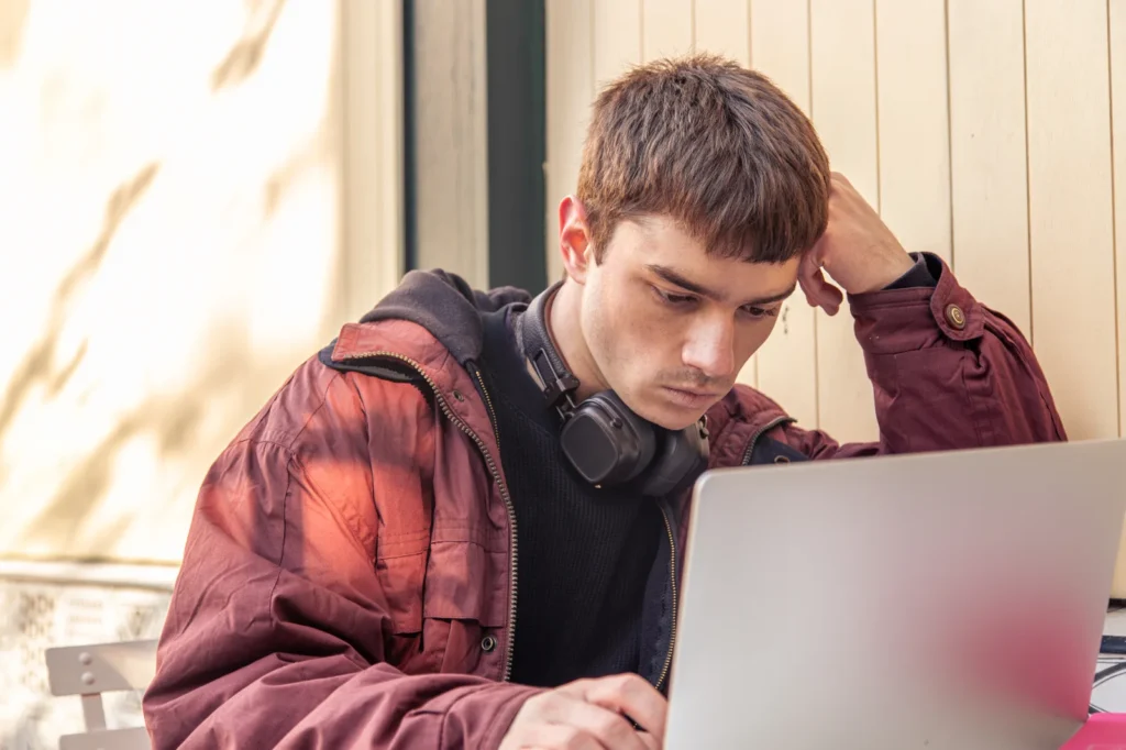 młody mężczyzna uczący się z laptopa